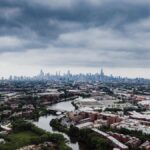 Stunning aerial view of Chicago skyline with dramatic clouds and river foreground.