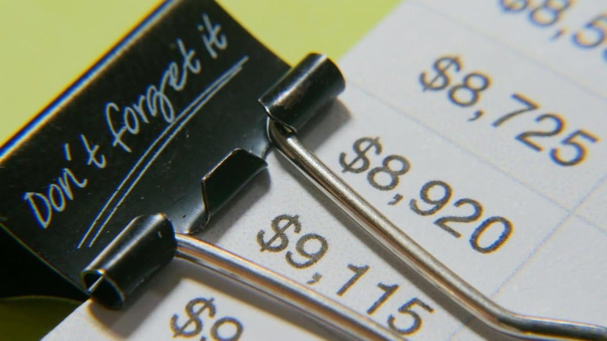 Close-up image showcasing a binder clip on a detailed financial report with highlighted amounts.