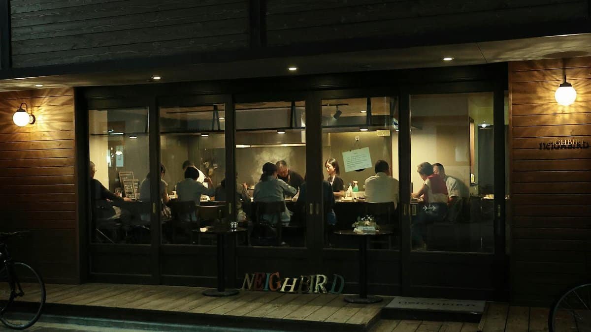 A view of people enjoying a relaxed gathering inside a modern coffee shop with wooden decor.