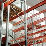 Bright modern warehouse featuring pallets and storage racks for logistics and inventory management.