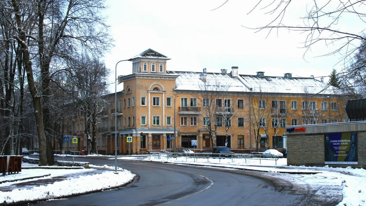 Snow-covered street in Narva, Estonia, featuring historic buildings and urban winter scenery.