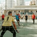 Goalkeeper prepares to defend during an indoor soccer game. Action-packed sports moment.