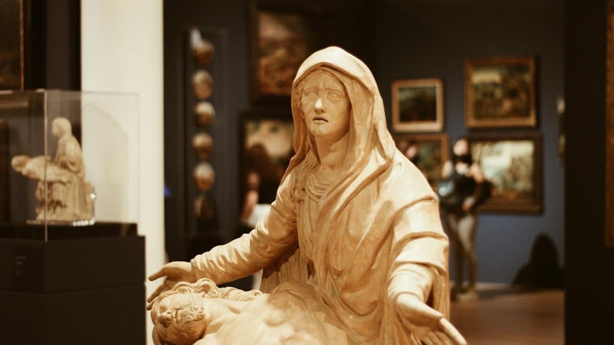 A detailed shot of a Pieta sculpture in a Mexico City museum surrounded by art.
