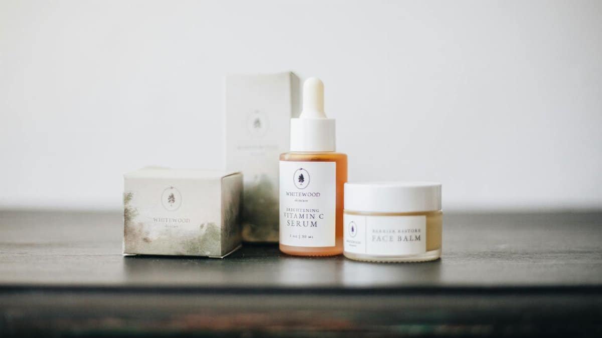 Elegant flat lay of natural skincare products, featuring a vitamin C serum and face balm.