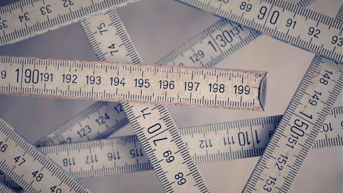 A collection of vintage folding rulers measuring in centimeters on a neutral background.