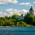 Scenic view of Washington State Capitol and surrounding greenery by the lake in Olympia.