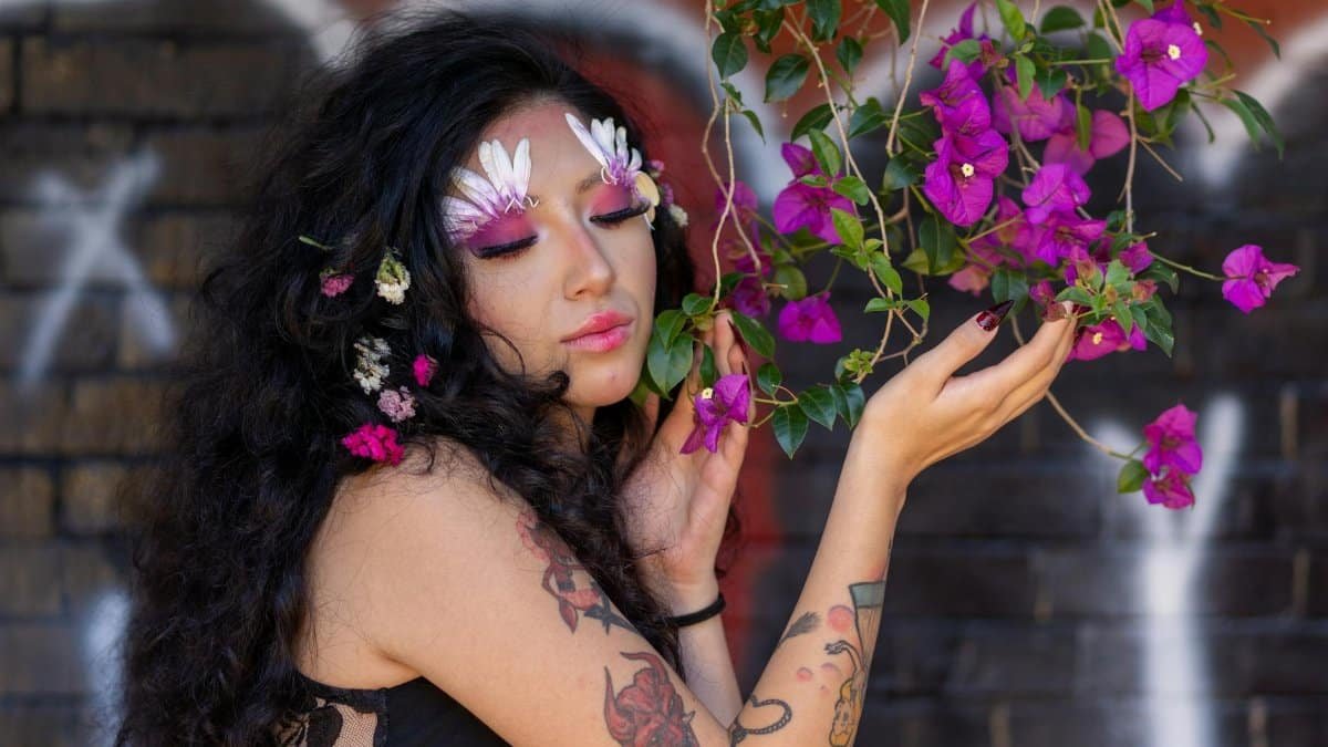 Stunning portrait of a woman with artistic makeup surrounded by vibrant bougainvillea in Mexico City.