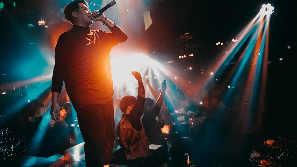 Energetic live performance with a singing artist in a vibrant nightclub atmosphere.