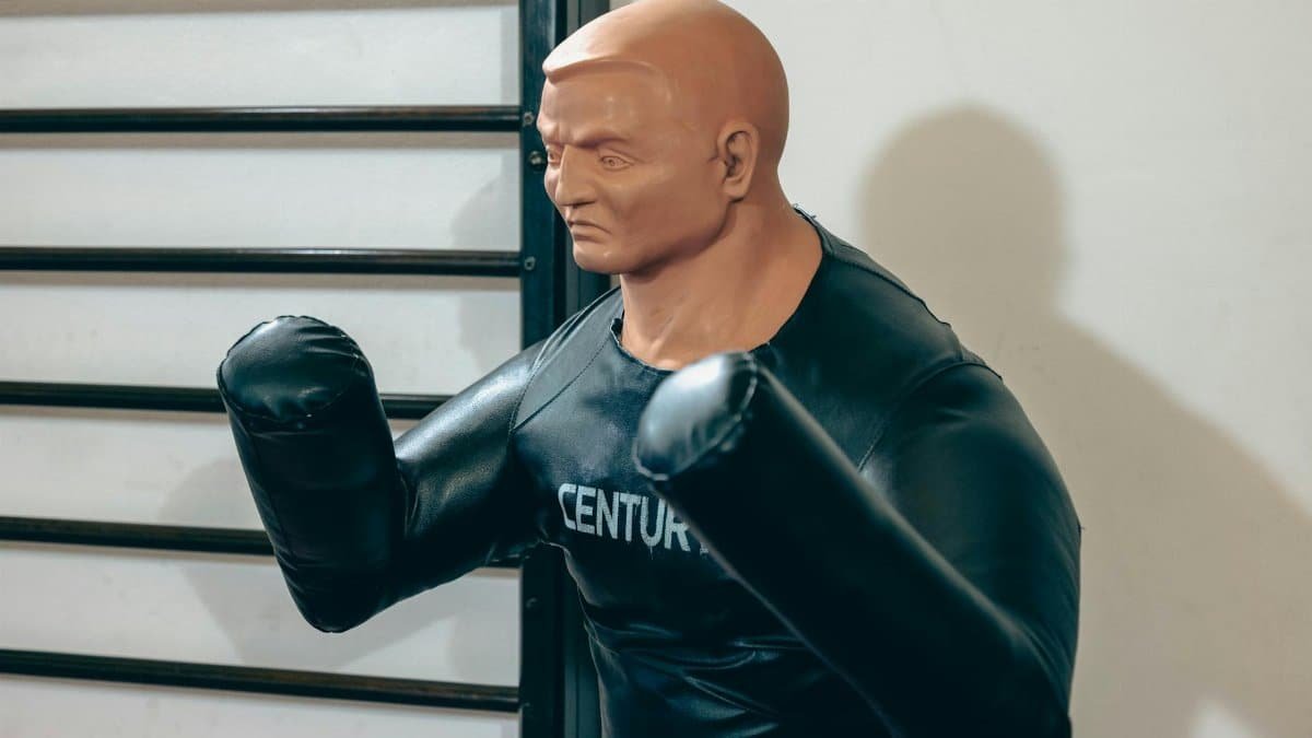 Realistic boxing dummy used for martial arts training in a gym.