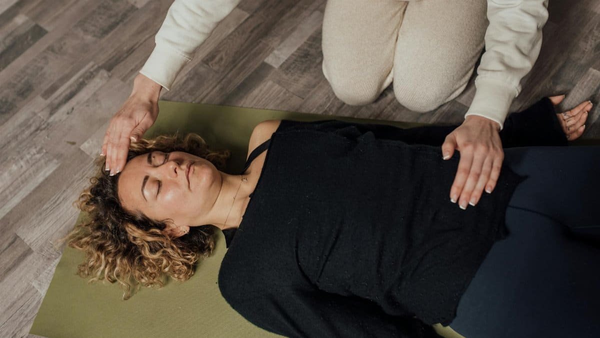 A woman practices holistic healing with eyes closed, focusing on relaxation and wellness.