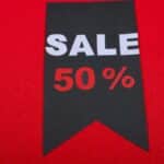 Modern sale tag offering 50% discount on vibrant red background.