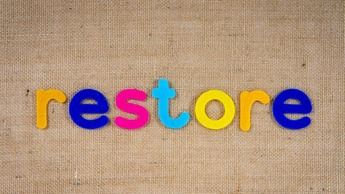 Vibrant colored letters spelling 'restore' on burlap texture, perfect for themes of renewal and recovery.