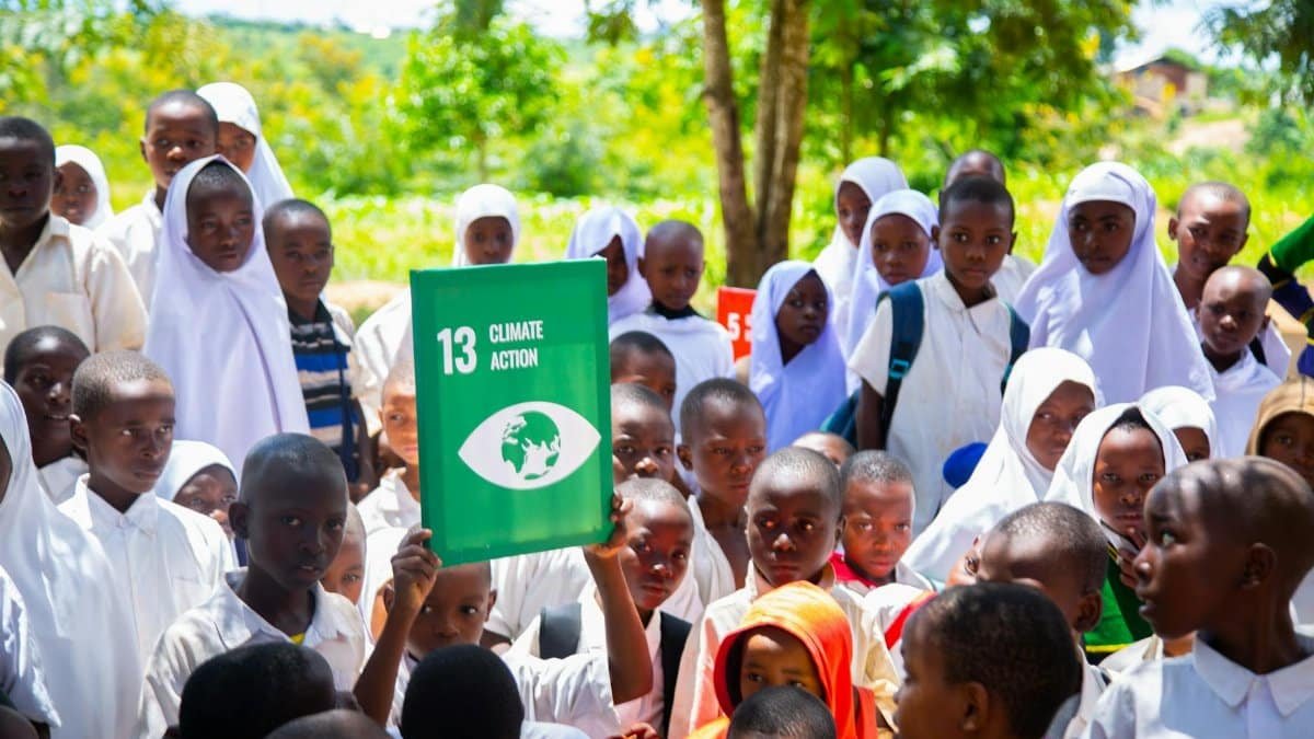 Group of children holding a Climate Action sign, promoting awareness for sustainable development.