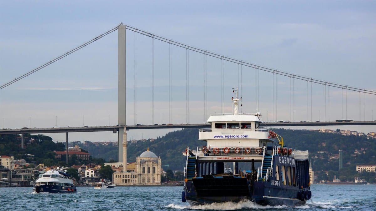 Ferries crossing the Bosphorus under the iconic İstanbul bridge.
