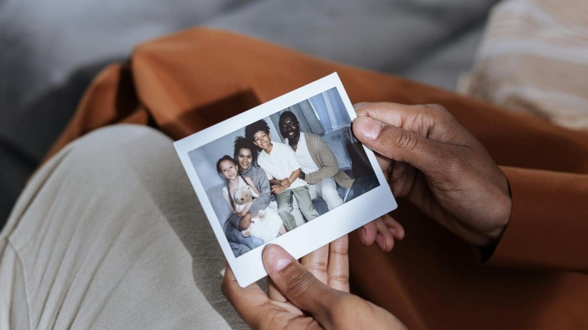 A close-up of hands holding a family photograph, emphasizing memories and connection.