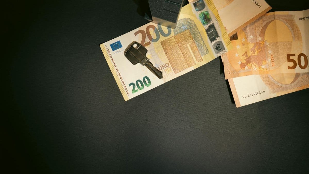 Flat lay of a house key on Euro bills representing real estate investment and finance.