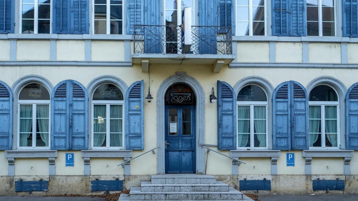 Classic building facade with blue shutters and door, showcasing European architecture.