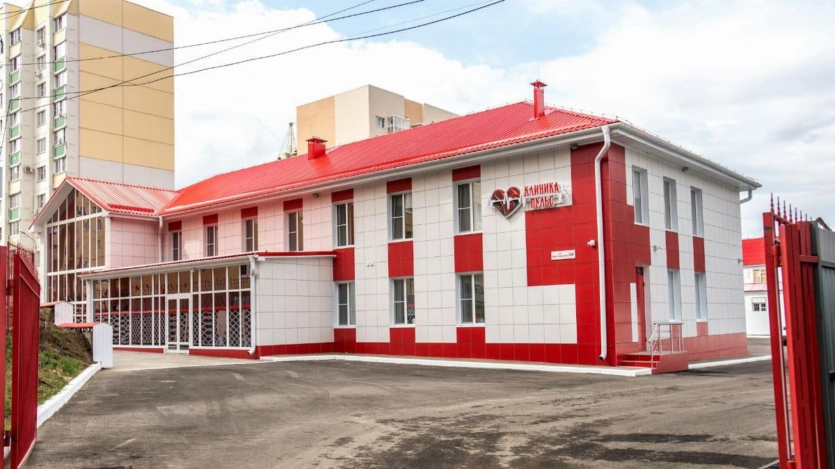 Modern clinic building with red and white facade, showcasing contemporary architecture.