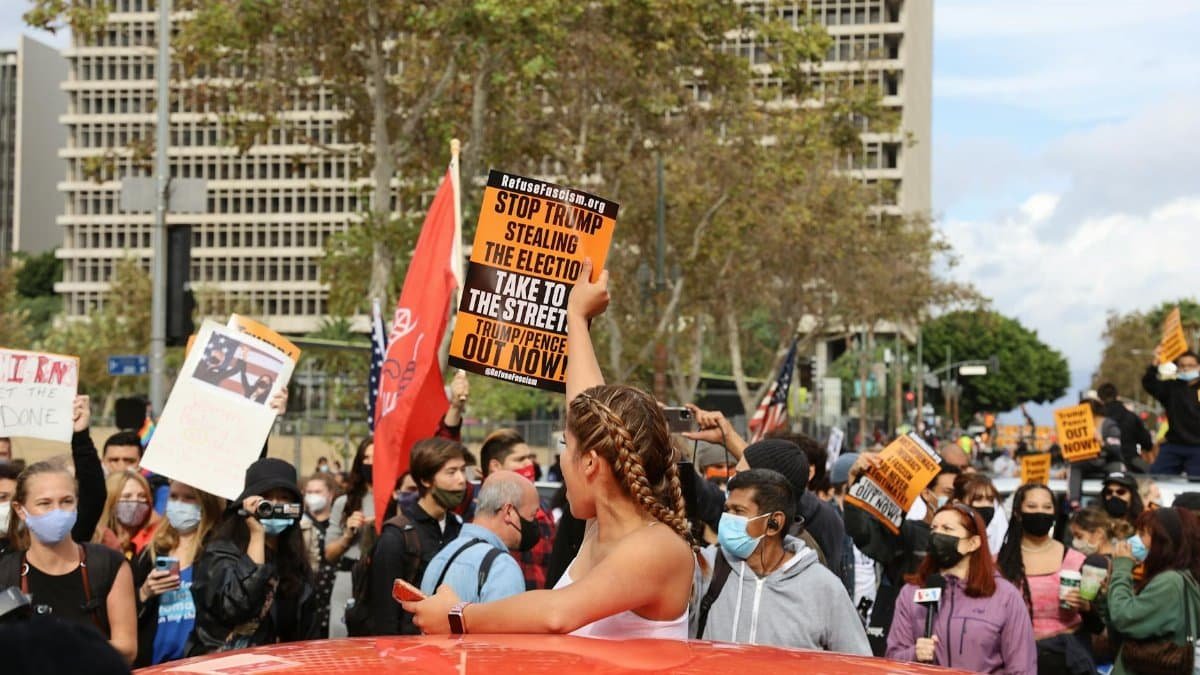 A diverse crowd protests in Los Angeles, advocating for political change and justice.