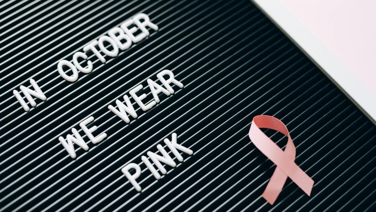 Letter board with 'In October We Wear Pink' message highlighting breast cancer awareness.