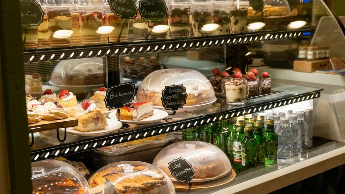 Delicious assortment of cakes and desserts displayed in a bakery case for customers.