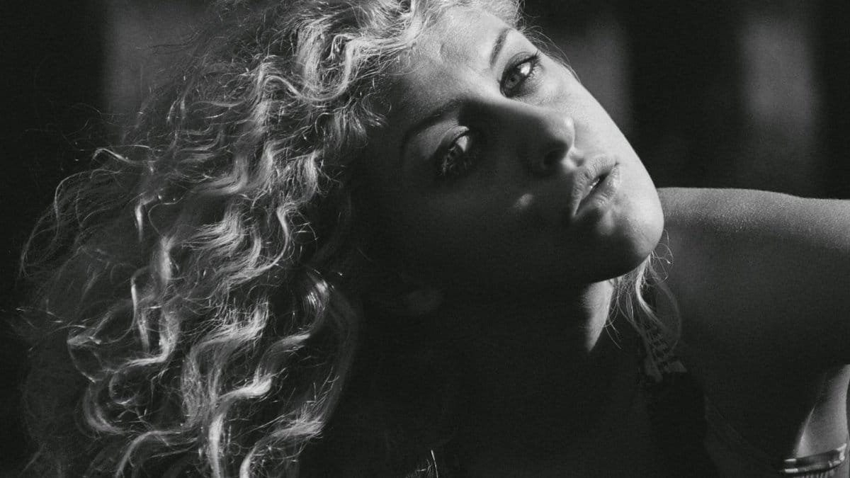 Dramatic black and white portrait capturing a woman's fierce gaze and curly hair.
