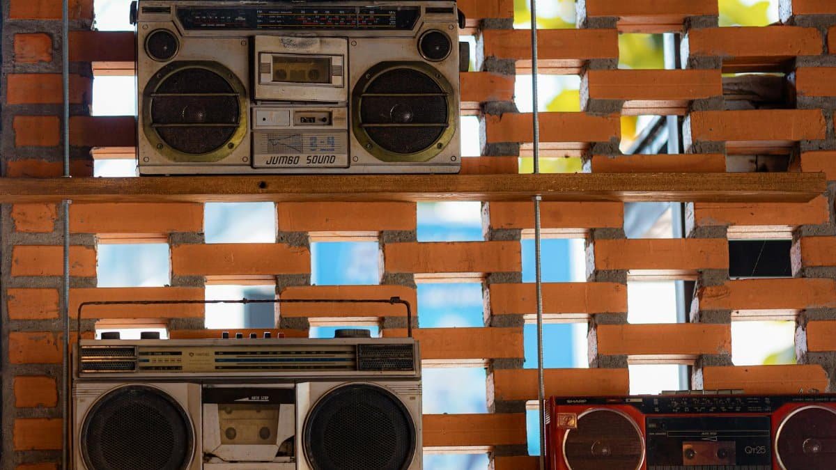 Collection of vintage boom boxes showcased on a rustic brick wall in Vietnam.