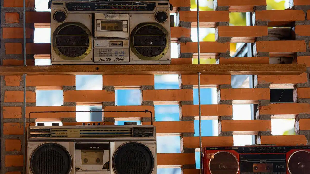 Collection of vintage boom boxes showcased on a rustic brick wall in Vietnam.