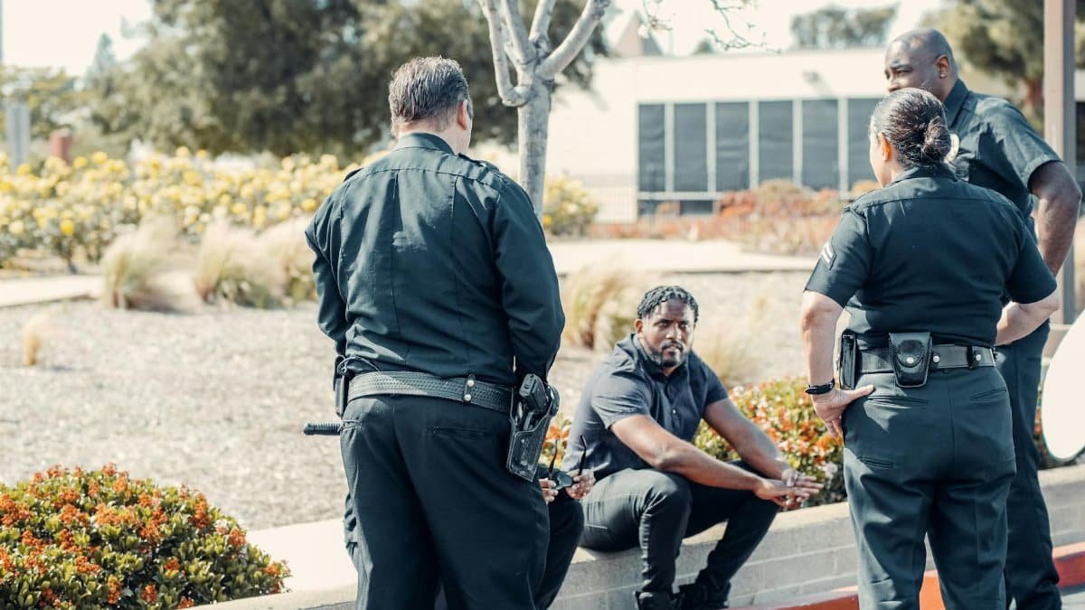 Law enforcement officers interacting with a person outdoors, displaying cooperation and safety enforcement.
