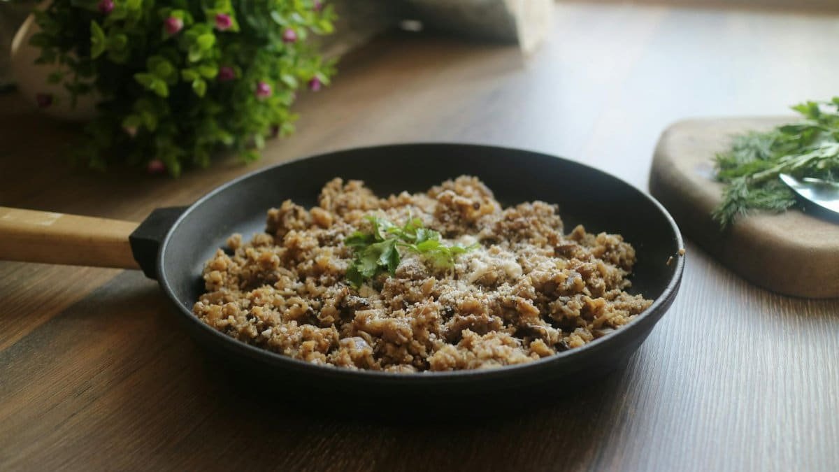 Tasty minced meat dish garnished with herbs in a black skillet, perfect for a delicious homemade meal.