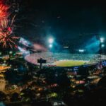 A vibrant display of fireworks over a packed stadium in Medellín, Colombia, creating a festive atmosphere.