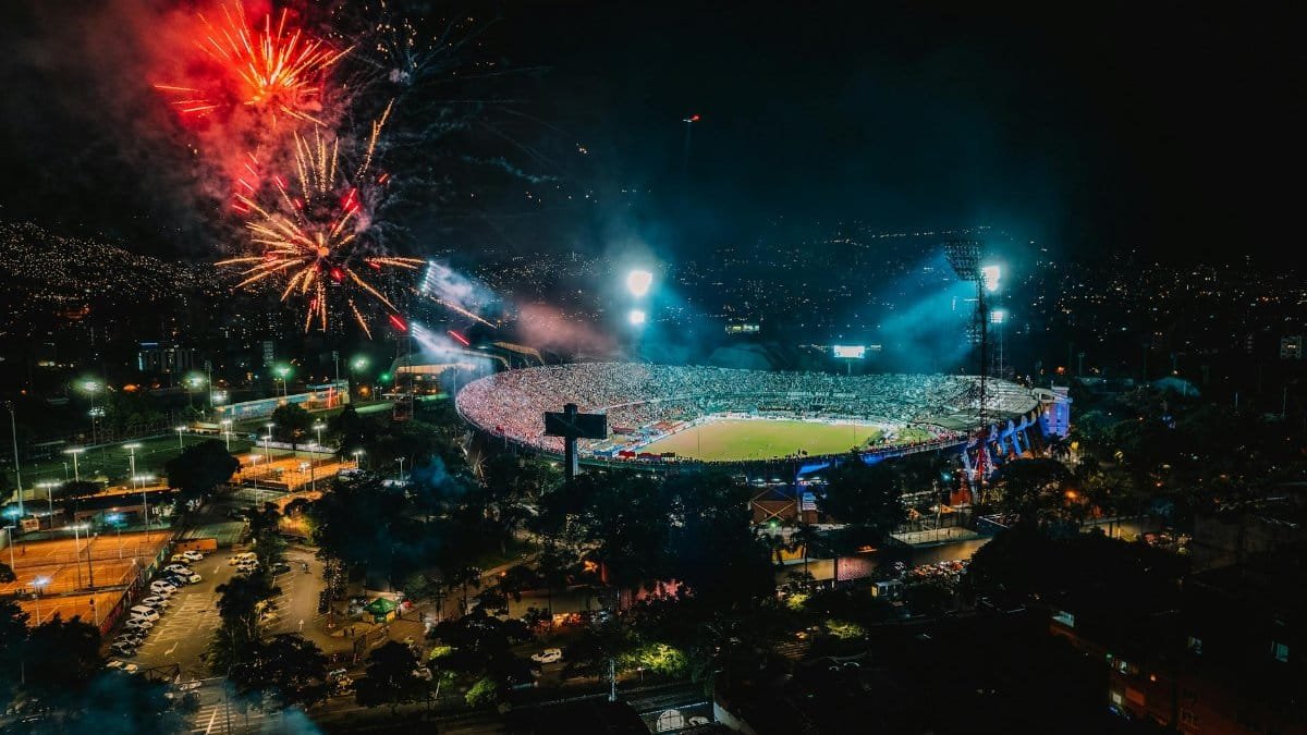 A vibrant display of fireworks over a packed stadium in Medellín, Colombia, creating a festive atmosphere.