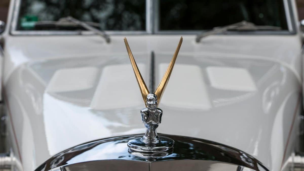 Detailed view of a Rolls Royce Spirit of Ecstasy on a white luxury car in Hamburg.