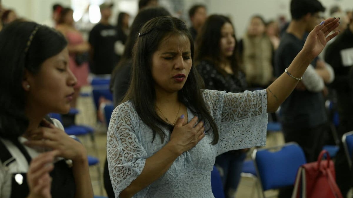 People engaged in prayer and worship in a religious gathering in Mexico City.