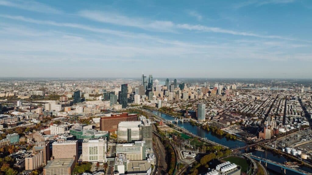 High-angle aerial view of Philadelphia showcasing the cityscape and skyline under a clear blue sky.