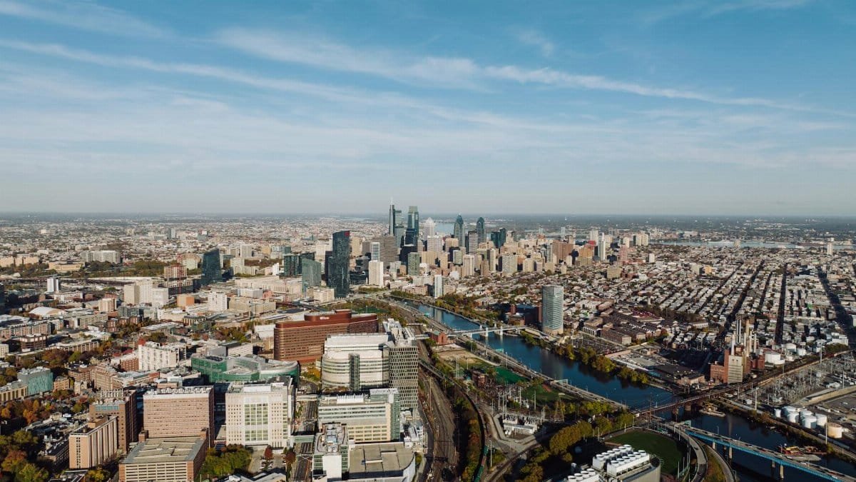 High-angle aerial view of Philadelphia showcasing the cityscape and skyline under a clear blue sky.