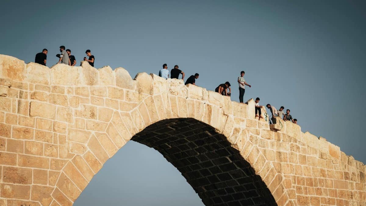 A group of people enjoying a sunny day on the historic Pira Delal bridge in Zakho, Iraq.