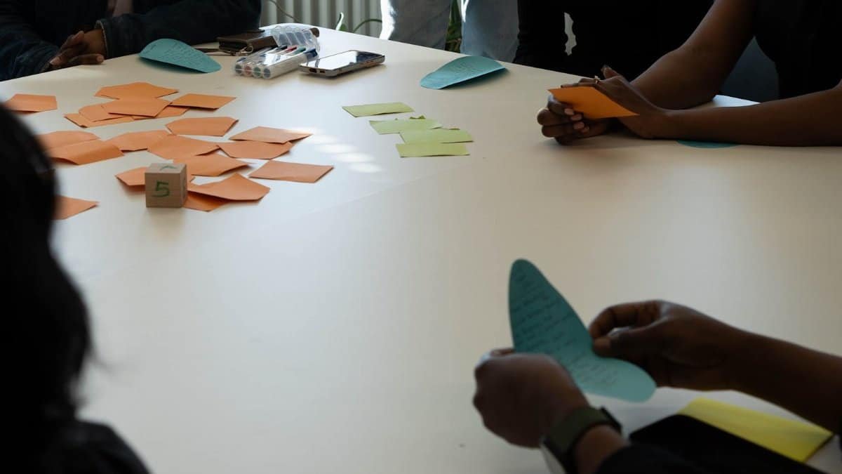 Team members in a collaborative meeting with colorful notes at a table, fostering creativity and planning.