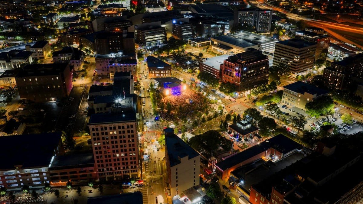 Vibrant night aerial view of downtown Chattanooga during a lively festival, showcasing city lights and bustling crowds.