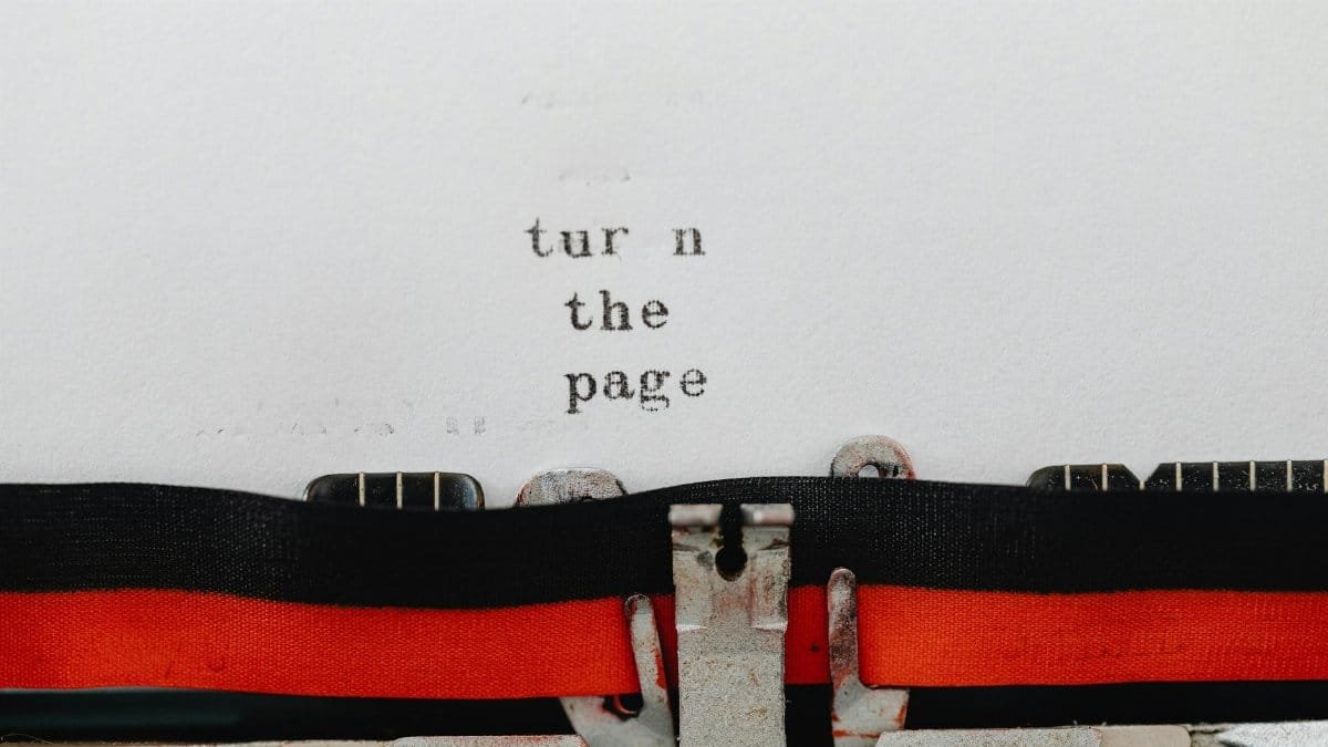 Close-up of a vintage typewriter with text 'turn the page' typed on paper, symbolizing change and new beginnings.