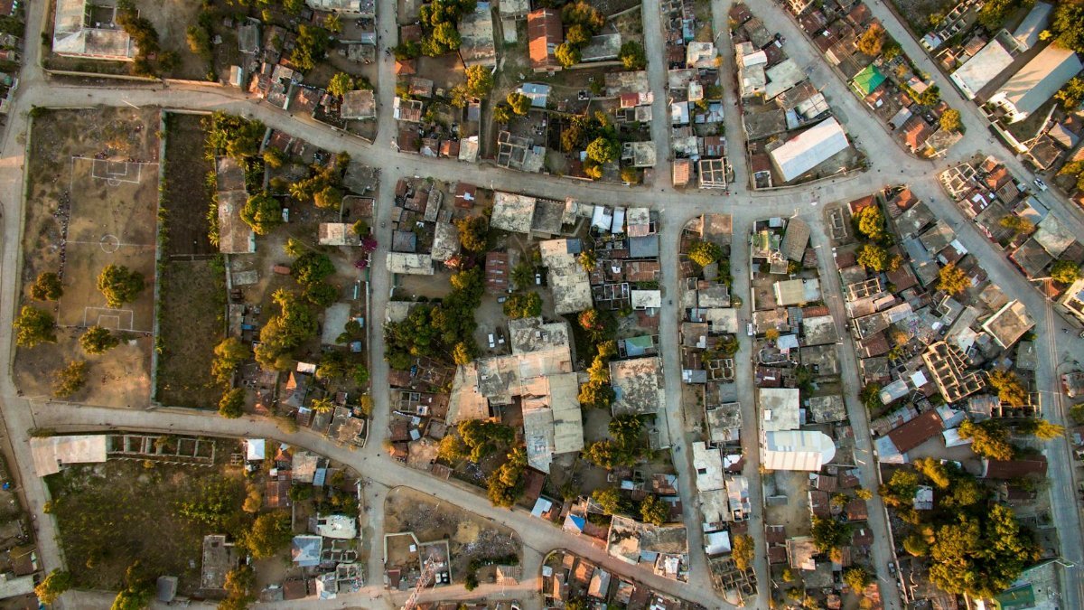 A high-angle aerial view of a bustling urban neighborhood in Haiti, showcasing roads and buildings.