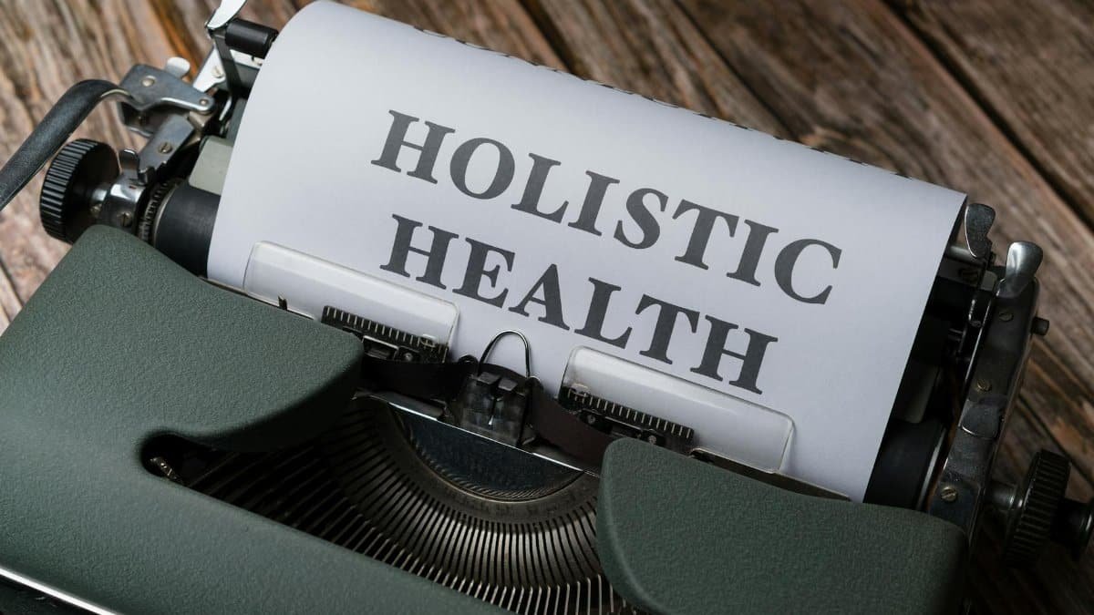 Close-up of a vintage typewriter with 'Holistic Health' on paper, representing wellness.