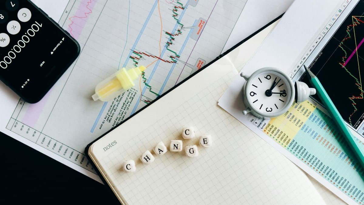 Top view of financial documents with charts, calculator, clock, and the word 'Change' in focus.