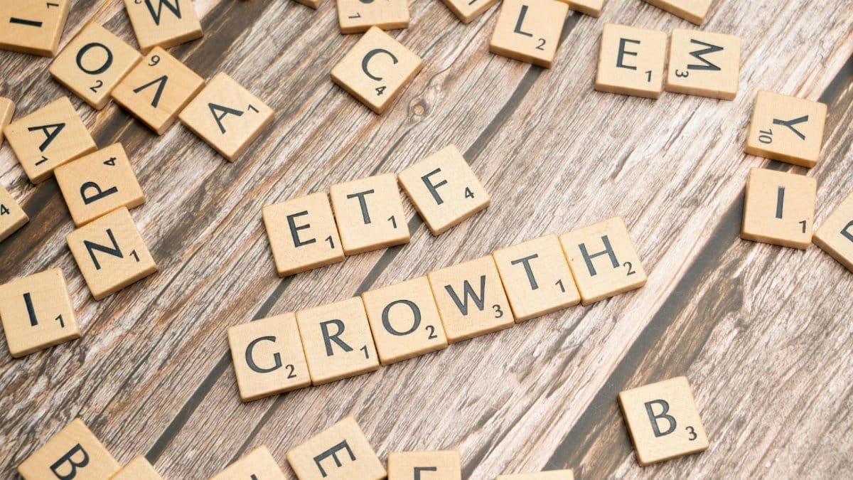 Wooden tiles spelling ETF growth on a wooden surface, symbolizing investment strategy.