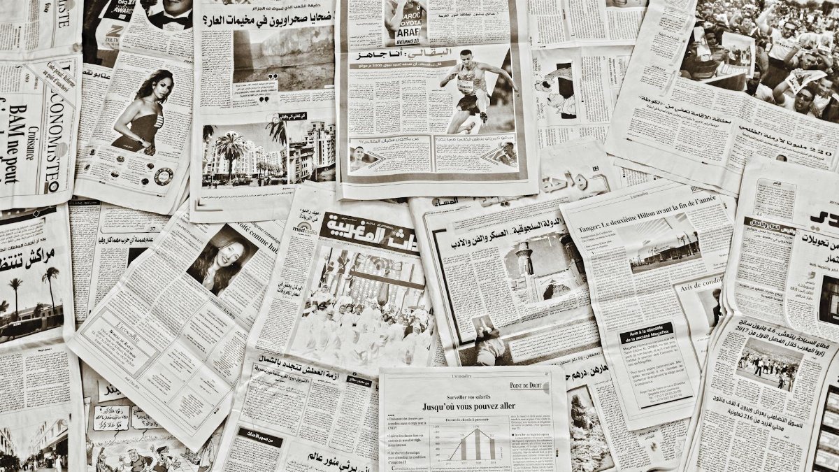 A flat lay of Arabic newspapers in Fès, Morocco, showcasing diverse articles.