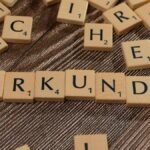 Wooden Scrabble tiles arranged on a textured surface forming words.