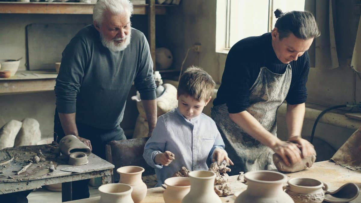 Elder, adult, and child working together in a pottery workshop, crafting ceramics.