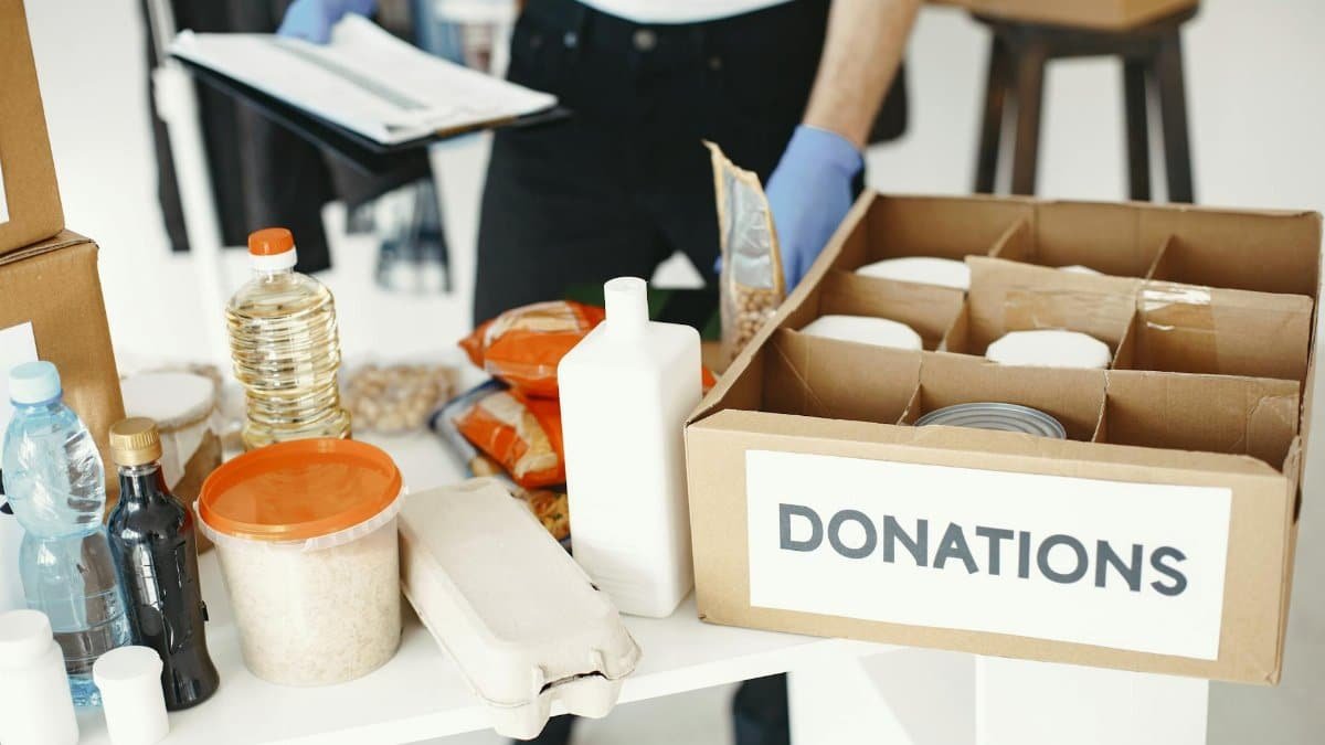 Close-up of donation box with various food items and supplies for community support.