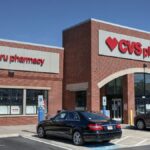 Brick CVS Pharmacy building with drive-thru, cars parked outside.