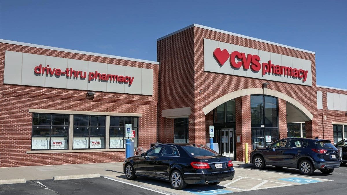 Brick CVS Pharmacy building with drive-thru, cars parked outside.